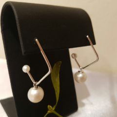 Zilveren oorbellen, hoekig model, met rond pareltje los in hangend en klein pareltje op het uiteinde.