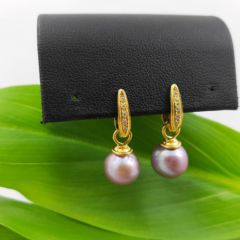 Geelgouden oorbellen met ronde parels. De parels zijn in natuurlijk donker roze. Op de oorbellen zitten echte diamantjes.