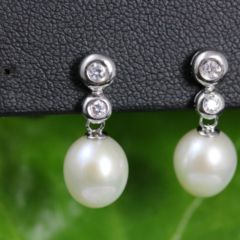 oorbellen zilver met parels. 2 zirconia steentjes onder elkaar en daarover een druppelvormige parel.